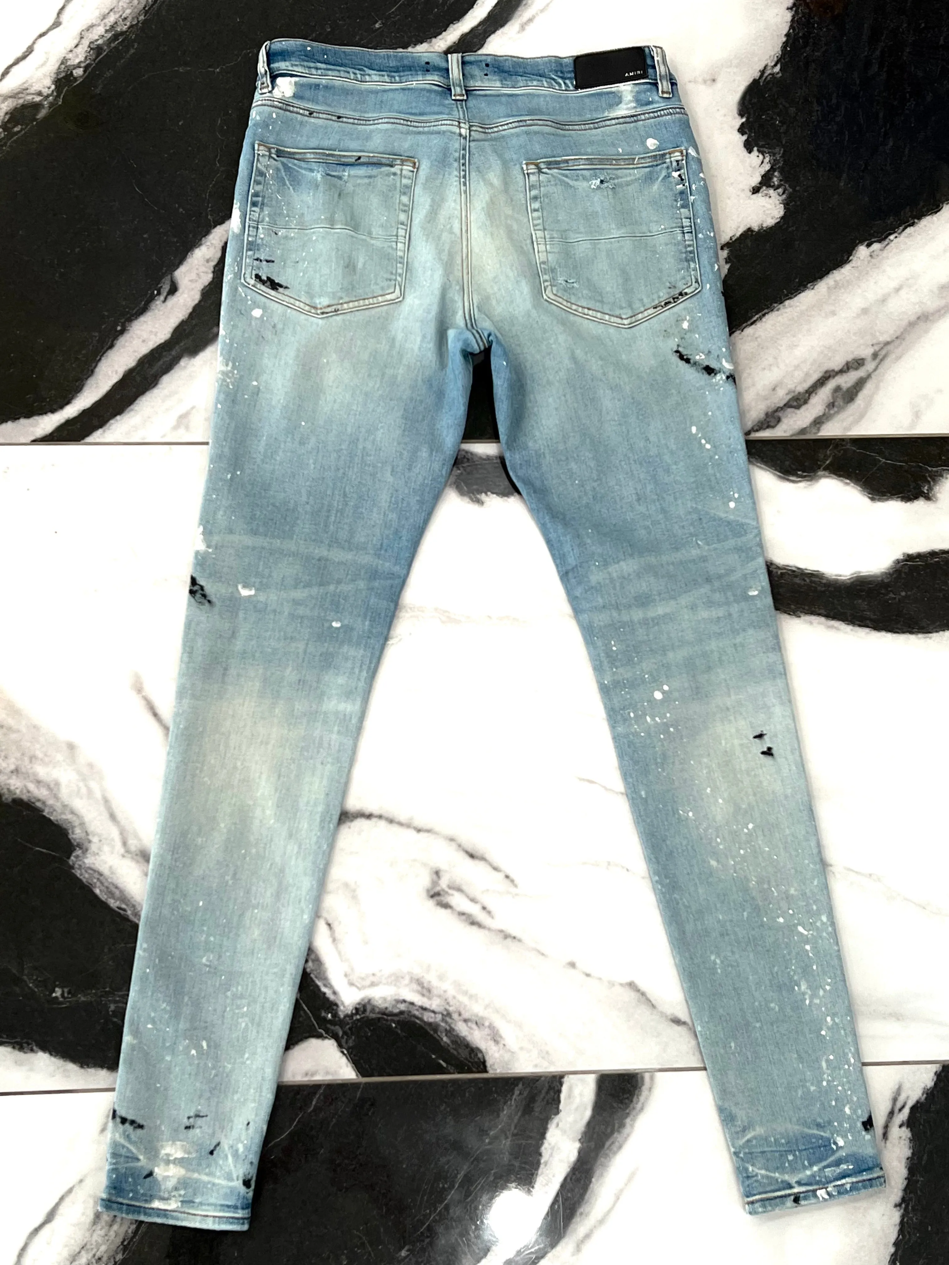 AMIRI PAINT SPLATTER DISTRESSED SKINNY JEANS