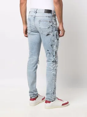 AMIRI PAINT SPLATTER DISTRESSED SKINNY JEANS